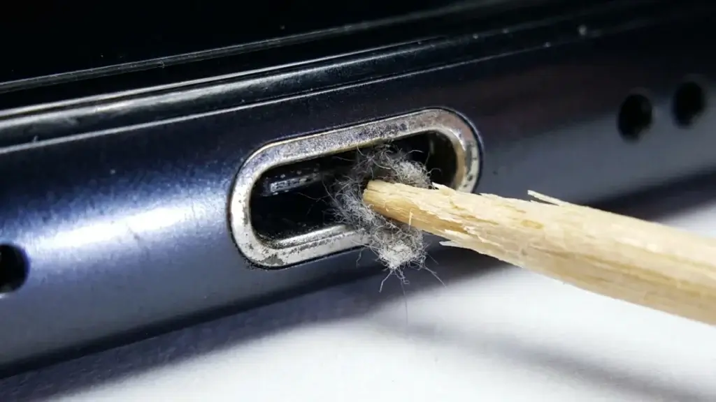 Cleaning lint out of a phone charging port with a wooden toothpick